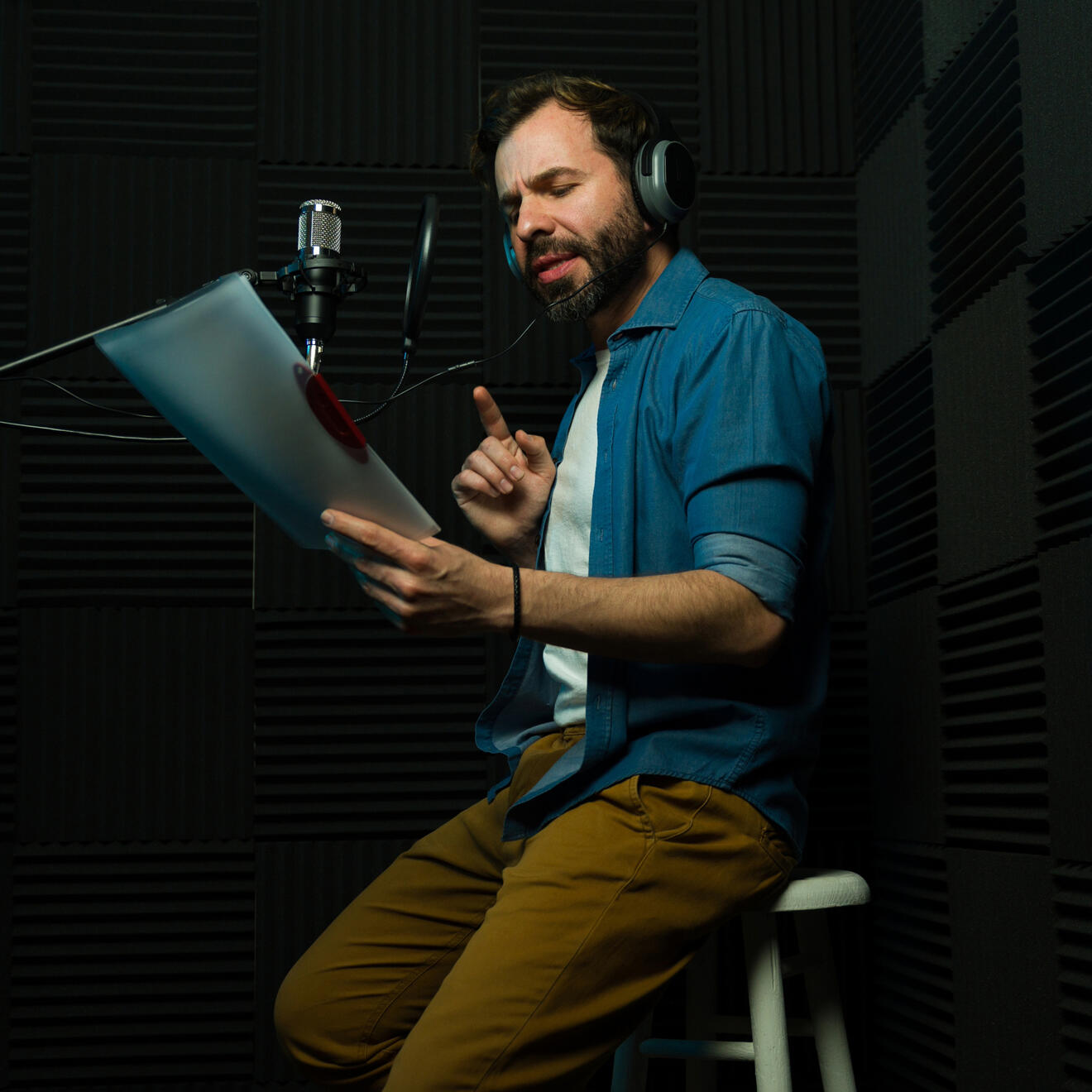 Professional voice actor recording voiceover audio in a studio for commercial, corporate video and media production