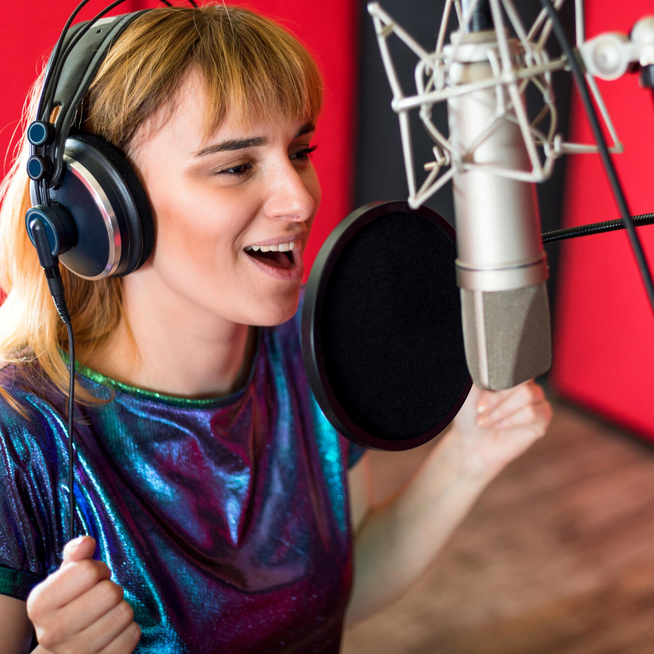 Female voiceover artist recording professional voiceover audio in a studio for commercials, corporate video and media production
